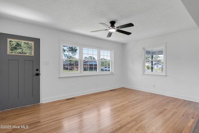 entryway with light wood-style flooring, a textured ceiling, ceiling fan, and a healthy amount of sunlight
