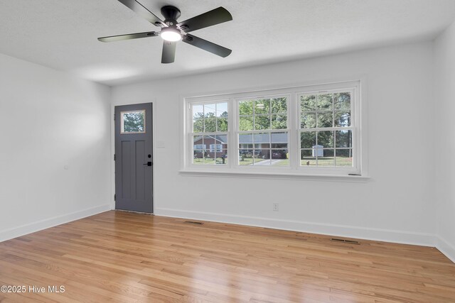 entrance foyer with a ceiling fan, baseboards, visible vents, and light wood-style floors