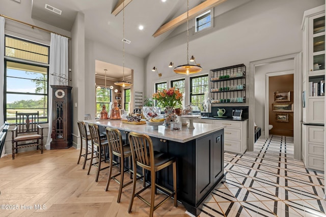 628 E Harborside Rd, Oriental, NC 28571 - kitchen featuring a breakfast bar area, a center island, visible vents, open shelves, and high vaulted ceiling