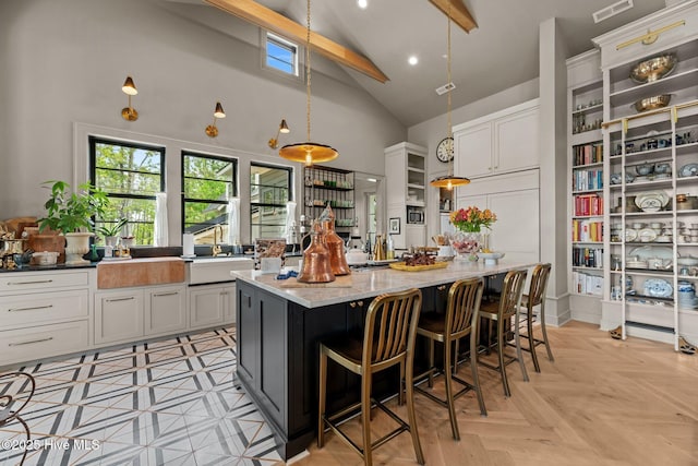 628 E Harborside Rd, Oriental, NC 28571 - kitchen with a center island, high vaulted ceiling, visible vents, light stone countertops, and beamed ceiling