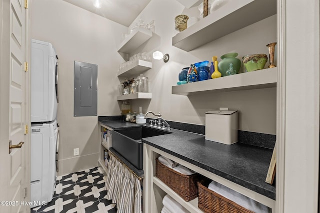 628 E Harborside Rd, Oriental, NC 28571 - kitchen with electric panel, dark floors, open shelves, stacked washing maching and dryer, and dark countertops