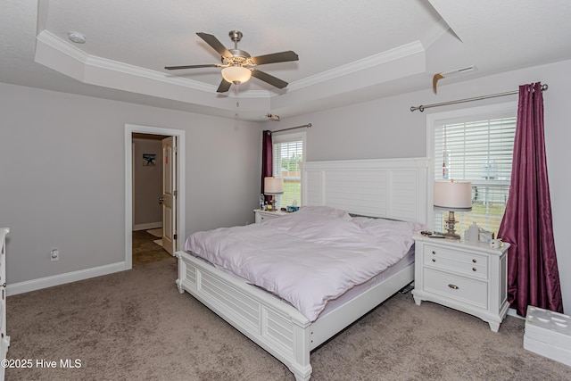 bedroom featuring crown molding, a tray ceiling, and light carpet