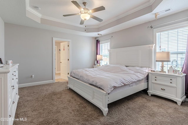 bedroom with a ceiling fan, visible vents, a raised ceiling, ornamental molding, and light carpet