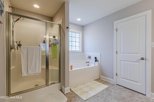 full bath with baseboards, a stall shower, and a bath