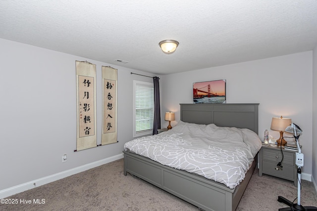 bedroom with baseboards, visible vents, a textured ceiling, and light colored carpet