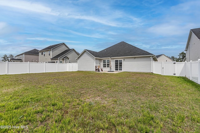 back of property with a fenced backyard, a gate, a patio, and a yard