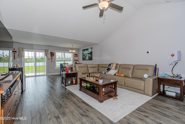 living room with baseboards, wood finished floors, lofted ceiling, and ceiling fan with notable chandelier