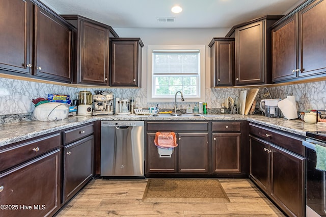 kitchen featuring dark brown cabinetry, a sink, light wood-style flooring, stainless steel dishwasher, and visible vents