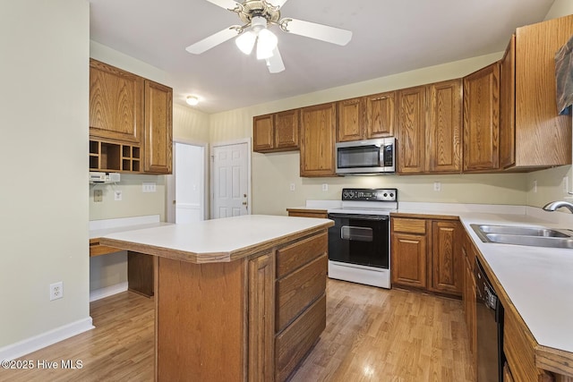 1601 Castalia Dr, Cary, NC 27513 - kitchen featuring stainless steel microwave, range with electric cooktop, a sink, and brown cabinets