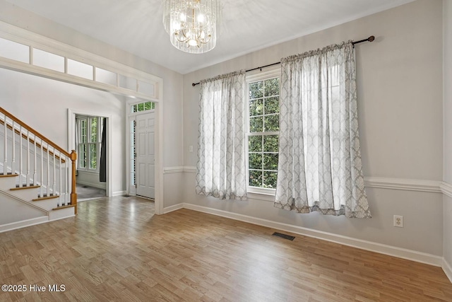 1601 Castalia Dr, Cary, NC 27513 - entryway with wood finished floors, stairs, a chandelier, and baseboards