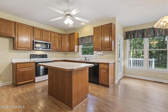 1601 Castalia Dr, Cary, NC 27513 - kitchen featuring electric stove, stainless steel microwave, black dishwasher, a sink, and light countertops