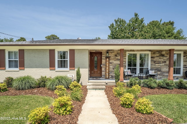 single story home featuring covered porch and brick siding