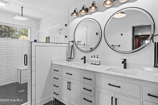 bathroom featuring double vanity, a sink, tile patterned flooring, and a stall shower