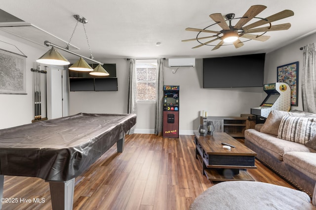 game room featuring a ceiling fan, pool table, a wall mounted AC, wood finished floors, and baseboards