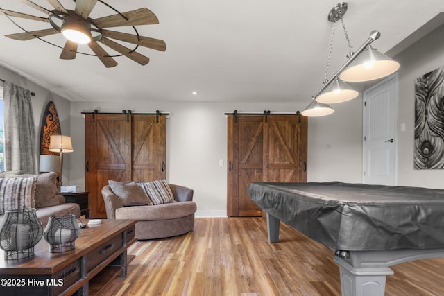 game room featuring light wood-style floors, a barn door, ceiling fan, and recessed lighting
