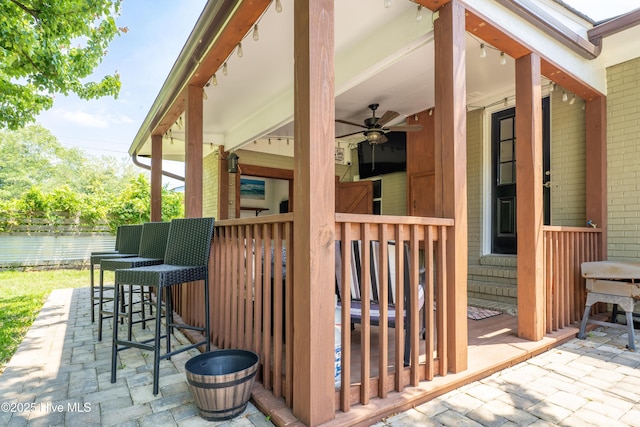 deck with a ceiling fan, a patio area, fence, and outdoor dry bar