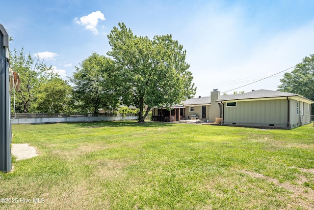 view of yard with fence, a water view, and a patio area