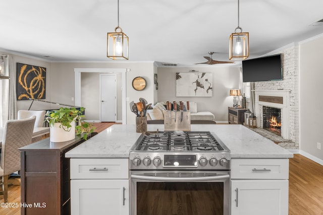 kitchen with stainless steel range with gas cooktop, open floor plan, and white cabinets