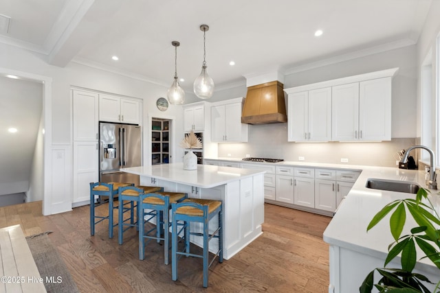 729 Waterstone Dr, Wilmington, NC 28411 - kitchen featuring custom exhaust hood, stainless steel appliances, a sink, a breakfast bar area, and a kitchen island