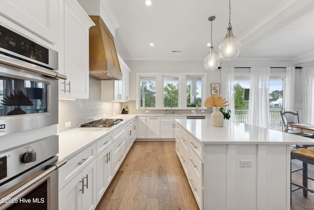 729 Waterstone Dr, Wilmington, NC 28411 - kitchen featuring stainless steel appliances, a breakfast bar area, backsplash, ornamental molding, and custom range hood