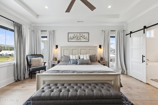 729 Waterstone Dr, Wilmington, NC 28411 - bedroom featuring a raised ceiling, a barn door, light wood-type flooring, a ceiling fan, and recessed lighting