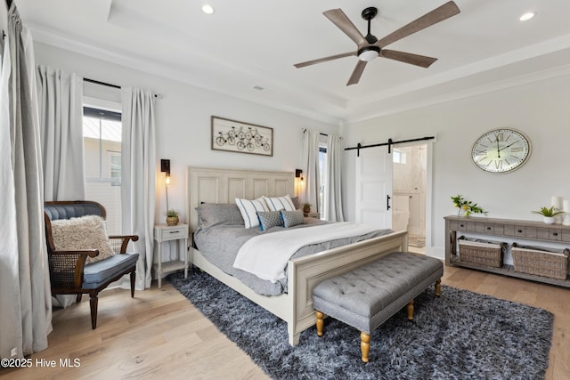 729 Waterstone Dr, Wilmington, NC 28411 - bedroom featuring a tray ceiling, a barn door, light wood-style floors, recessed lighting, and crown molding