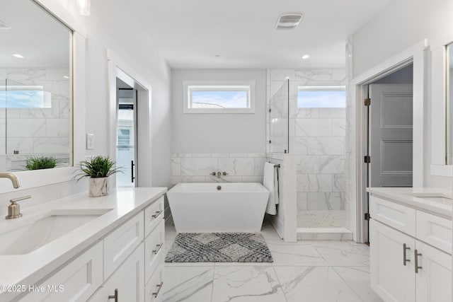 729 Waterstone Dr, Wilmington, NC 28411 - full bath featuring marble look tiles, a marble finish shower, two vanities, a freestanding bath, and recessed lighting