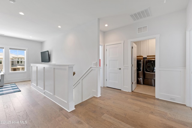 729 Waterstone Dr, Wilmington, NC 28411 - hall with independent washer and dryer, a decorative wall, light wood-style flooring, wainscoting, and recessed lighting