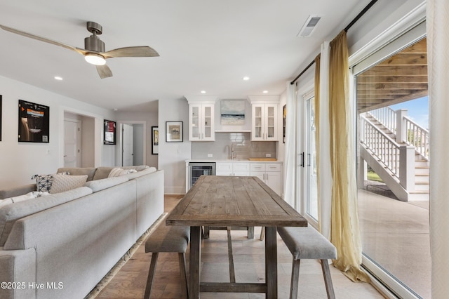 729 Waterstone Dr, Wilmington, NC 28411 - dining space featuring wet bar, beverage cooler, light wood finished floors, a baseboard radiator, and a ceiling fan