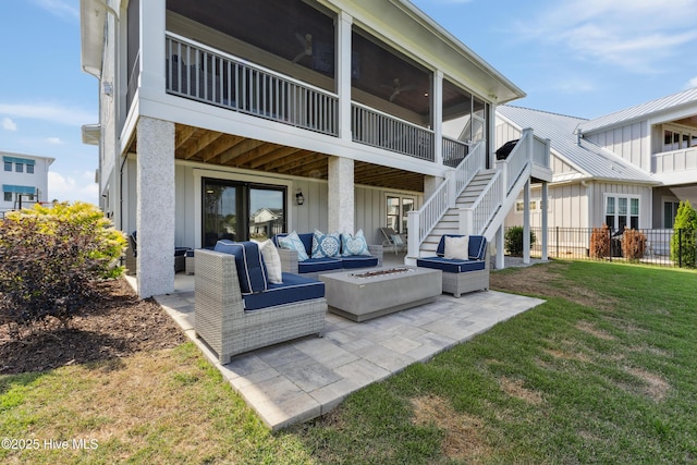 729 Waterstone Dr, Wilmington, NC 28411 - rear view of house with board and batten siding, an outdoor living space with a fire pit, a patio, and stairway