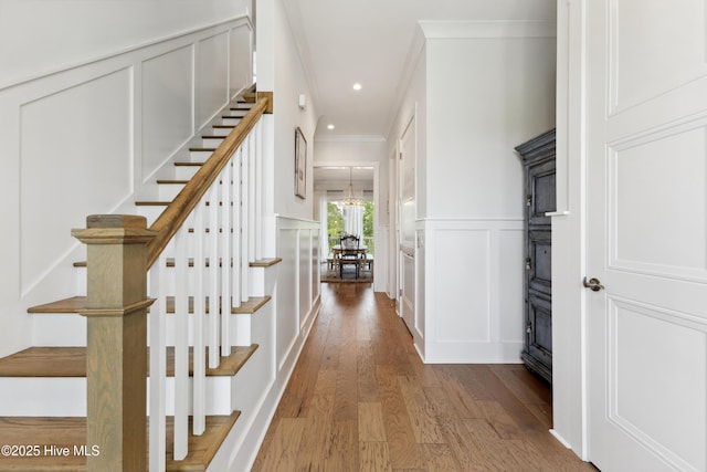 729 Waterstone Dr, Wilmington, NC 28411 - hallway with a decorative wall, crown molding, hardwood / wood-style floors, stairway, and a wainscoted wall