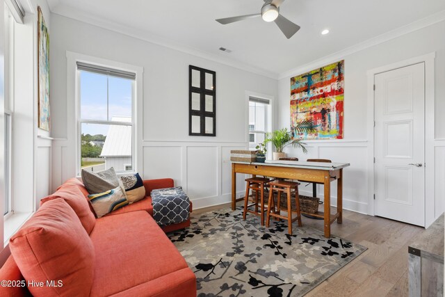 729 Waterstone Dr, Wilmington, NC 28411 - living room featuring ornamental molding, a decorative wall, a ceiling fan, and a wainscoted wall