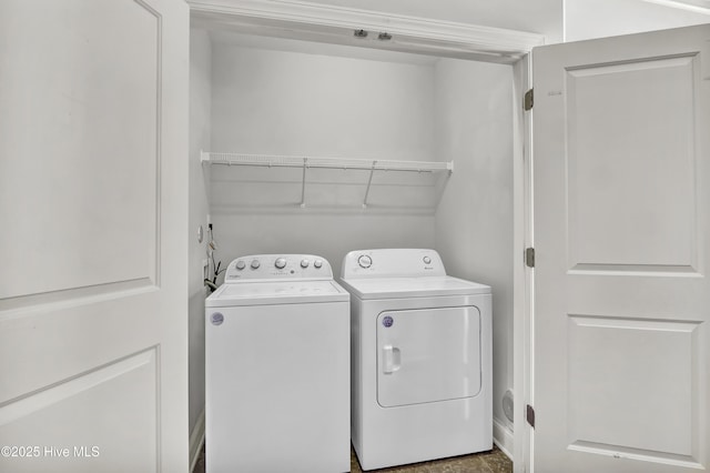 clothes washing area featuring separate washer and dryer and laundry area