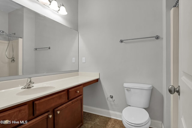 bathroom featuring toilet, baseboards, and vanity