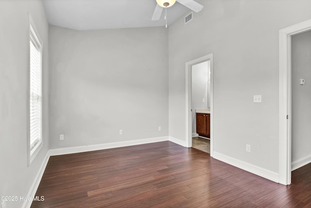 spare room with plenty of natural light, a ceiling fan, and dark wood-type flooring