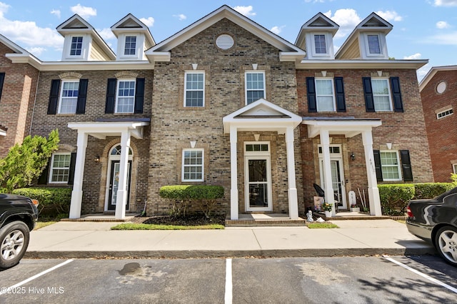 townhome / multi-family property with uncovered parking and brick siding