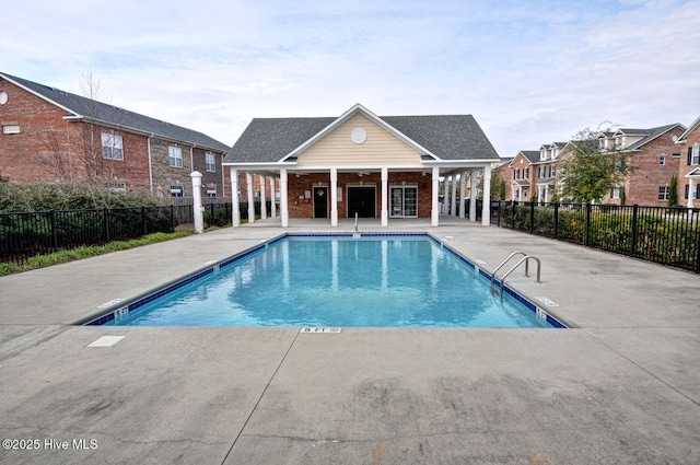 community pool with a patio and fence