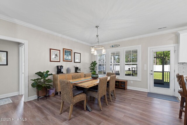 dining area with crown molding, baseboards, and wood finished floors