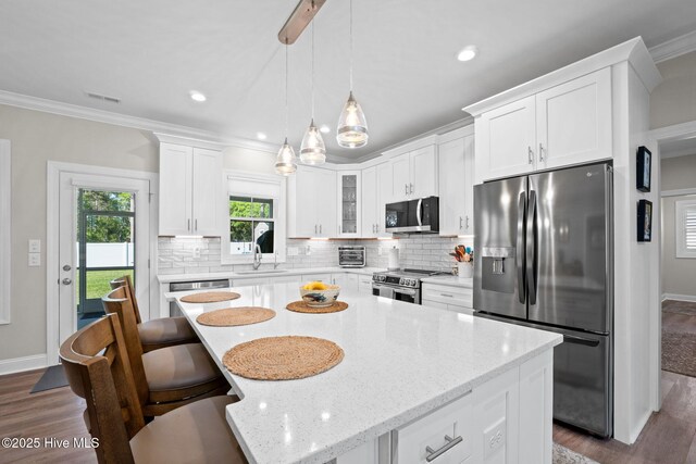 kitchen featuring appliances with stainless steel finishes, tasteful backsplash, baseboards, white cabinets, and dark wood-type flooring