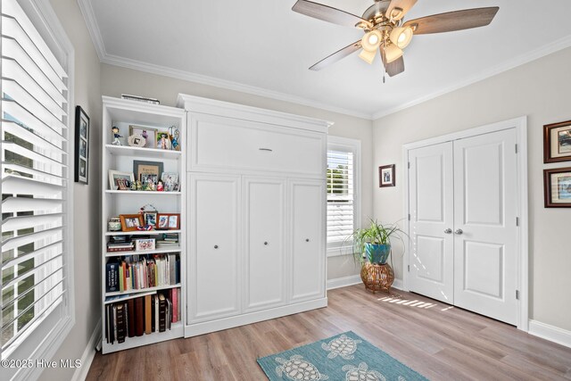 entrance foyer featuring baseboards, ornamental molding, light wood-style flooring, and ceiling fan