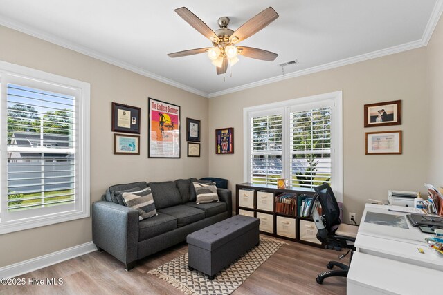 office area with light wood-style floors, a ceiling fan, plenty of natural light, and visible vents