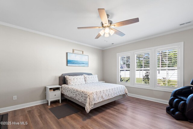 bedroom featuring crown molding, ceiling fan, baseboards, wood finished floors, and visible vents