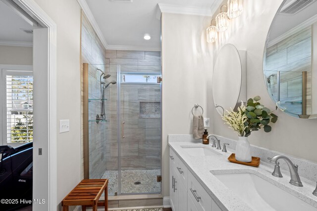 bathroom featuring crown molding, visible vents, a shower stall, and a sink