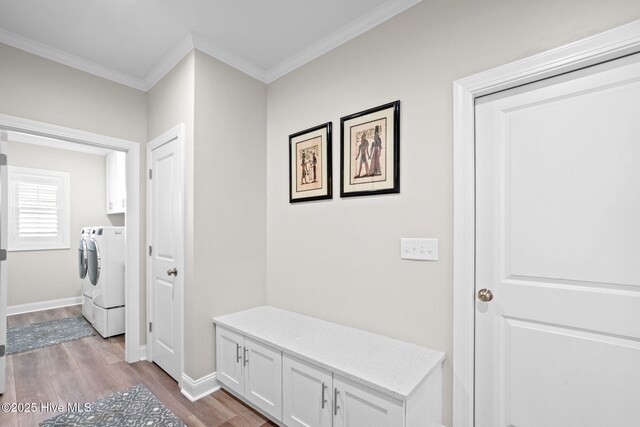 mudroom featuring independent washer and dryer, crown molding, baseboards, and wood finished floors
