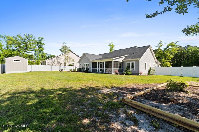 back of house with a sunroom, a gate, a fenced backyard, and a yard