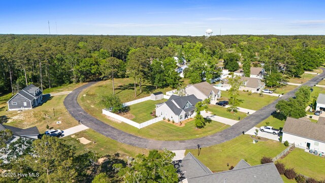 drone / aerial view featuring a residential view and a wooded view