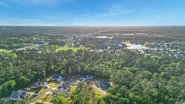 birds eye view of property featuring a water view and a wooded view