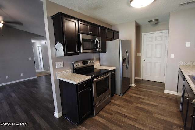 kitchen with a ceiling fan, visible vents, dark wood finished floors, light countertops, and stainless steel appliances