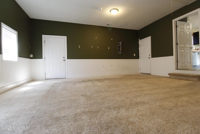carpeted spare room featuring wainscoting