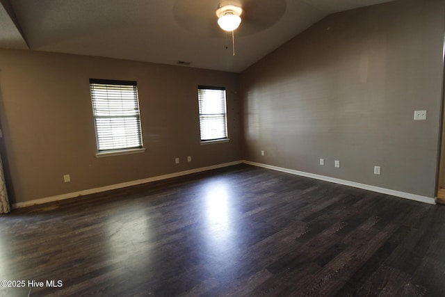 unfurnished room featuring baseboards, ceiling fan, dark wood-type flooring, and lofted ceiling